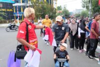 GANDENG LAUNG KUNING, POLDA KALSEL BAGIKAN RIBUAN BENDERA MERAH PUTIH